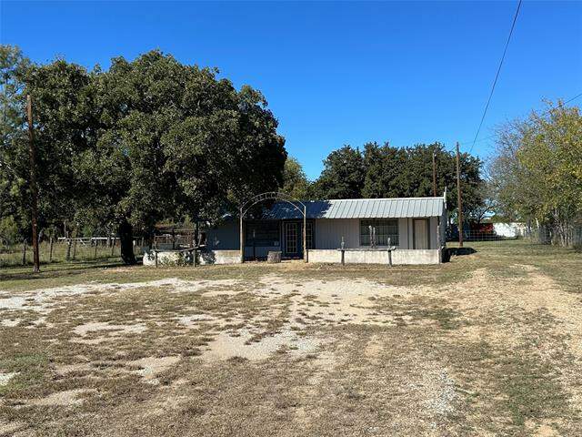 Image of a house, there is patches of grass in the front yard.