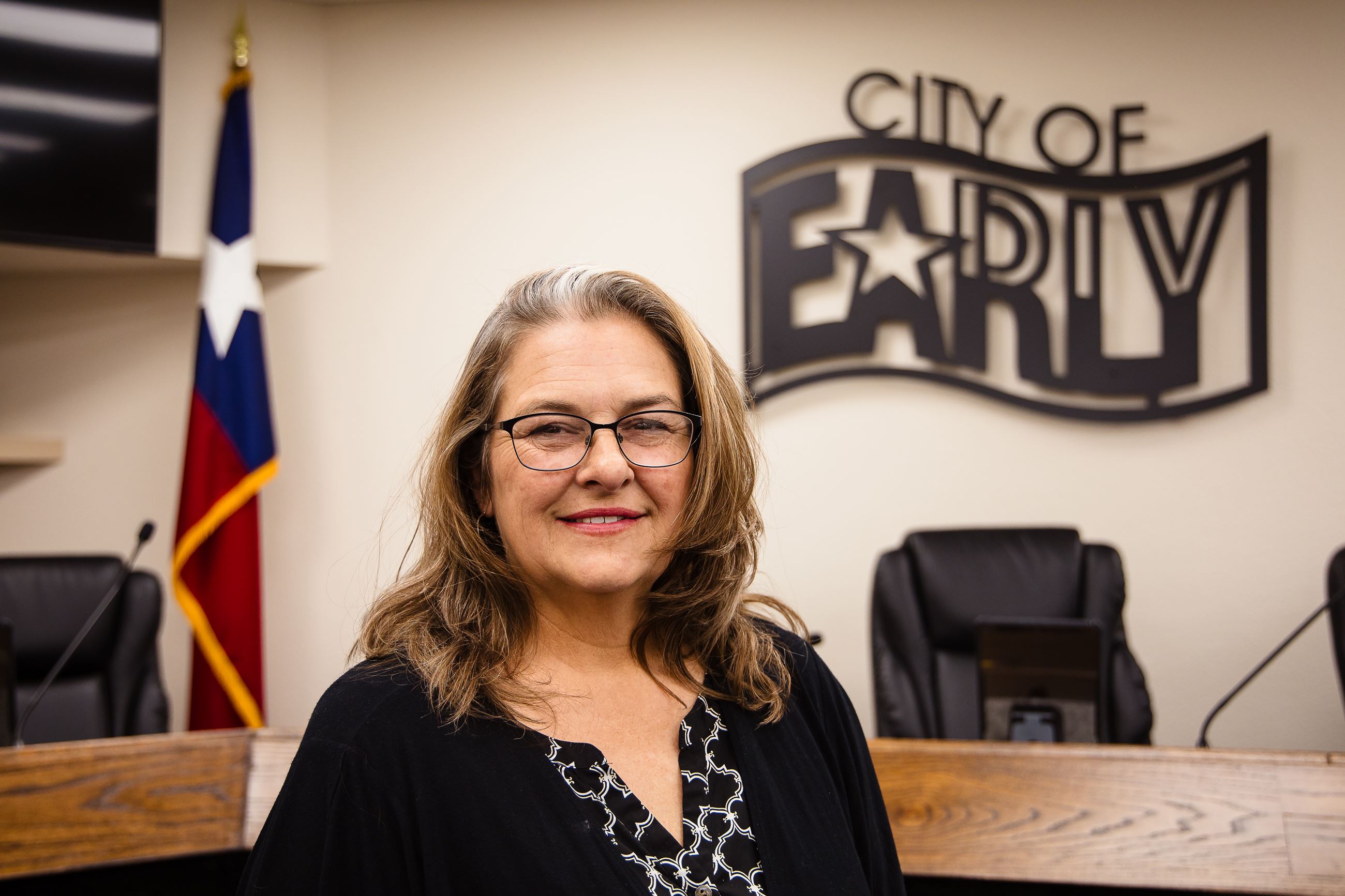 Picture of a lady in front of City logo