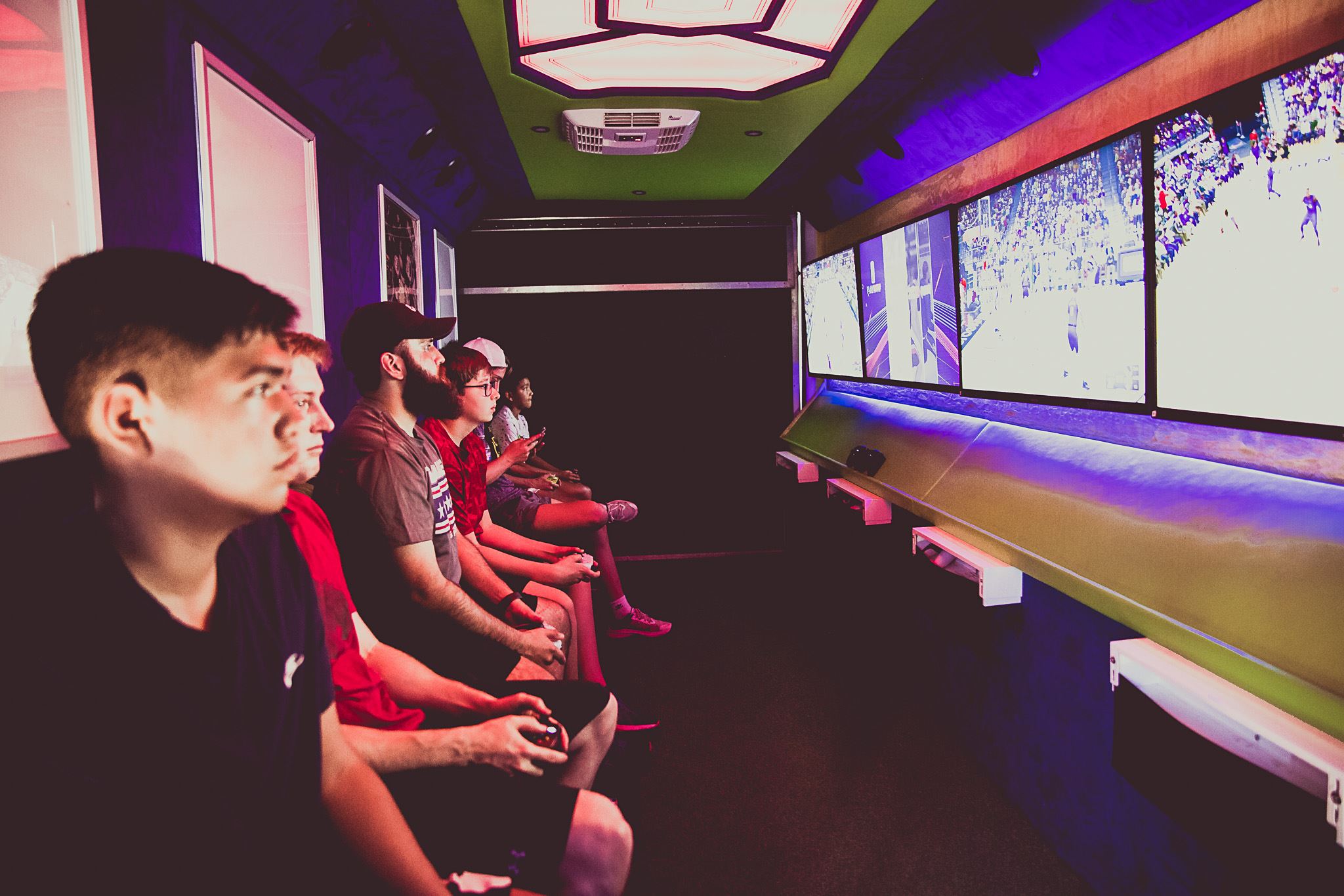 Pictures inside a gaming trailer with guys playing video games 