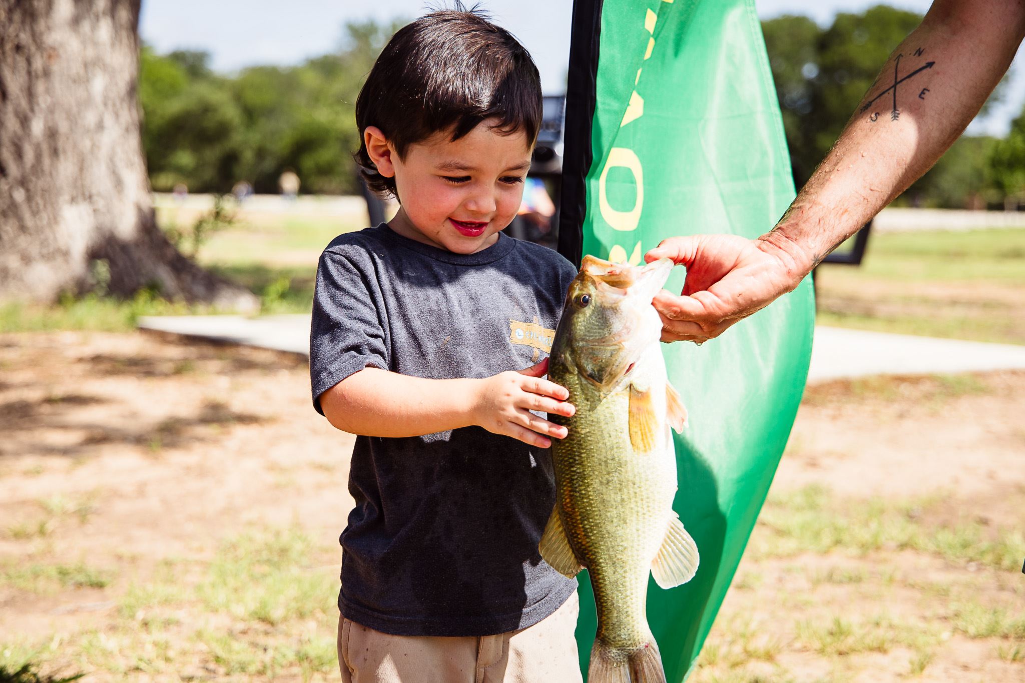 Pictures of a little boy holding a bass fish